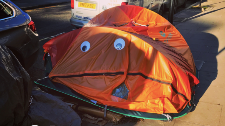 orange tent with smiley face stuck on