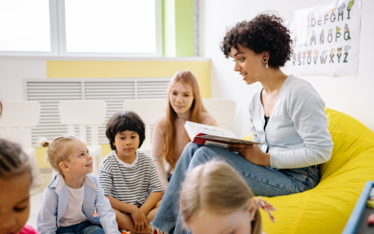 An image of a teacher reading to a group of young children