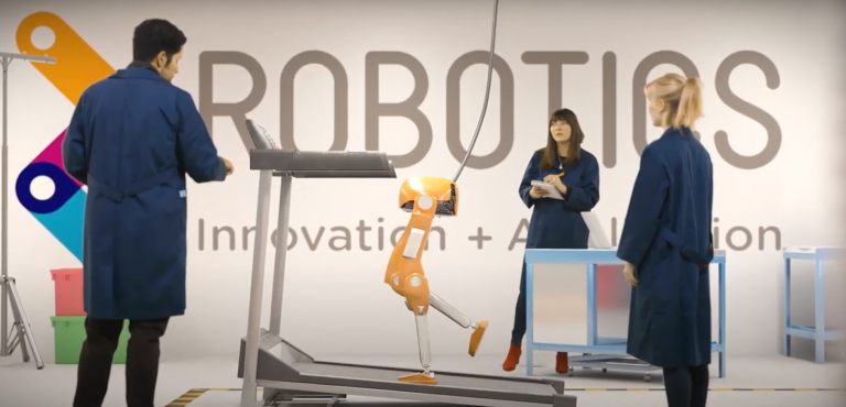 A man and two women stood in a robotics lab