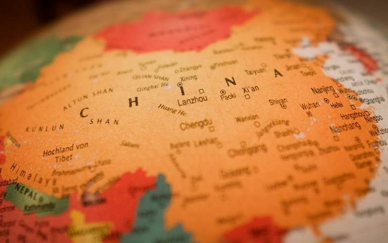 China on a glowing globe (Christian Lue - Unsplash)