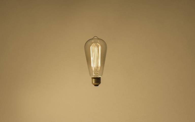 Lighted clear light bulb floating in mid air