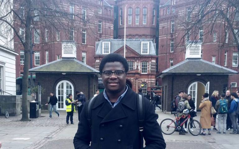 Student standing in front of UCL building entrance