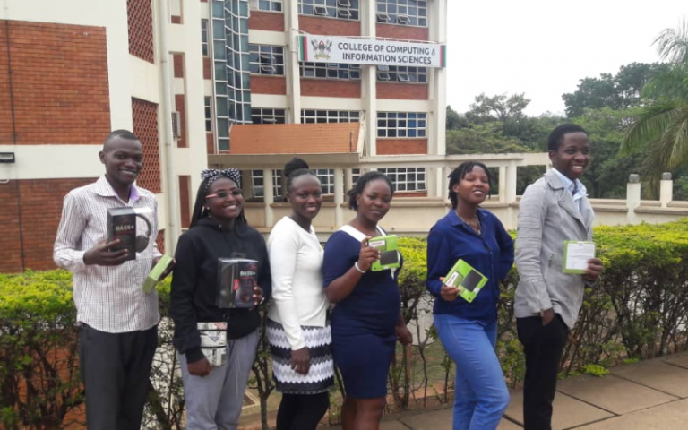 Six Ugandan university students standing in front of the College of Computing & Information Sciences