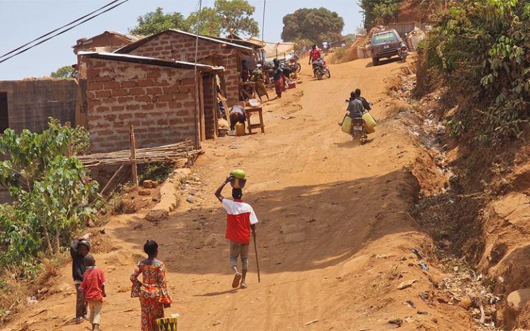 Moyiba residents walking up steep rocky hill in Freetown