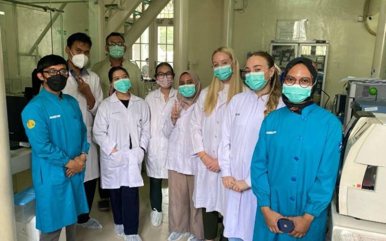 Dr Rhian Convery and Phoebe Foster taking a tour of the laboratory with the Jakarta research team 