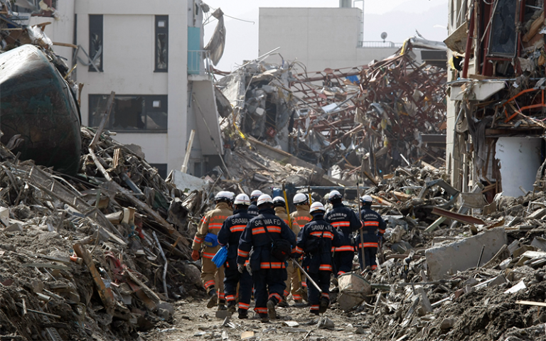 Rescue Team searching operation on debris and mud covered at Tsunami hit Destroyed city in Rikuzentakata on March 20, 2011, Japan