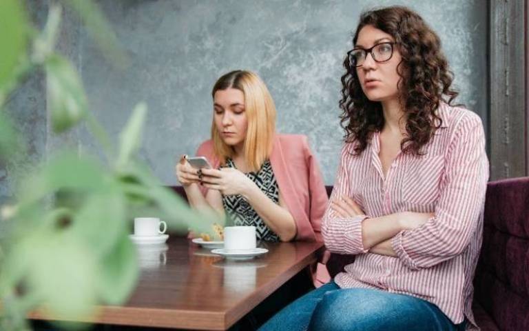 Two girls in a coffee shop on their phones