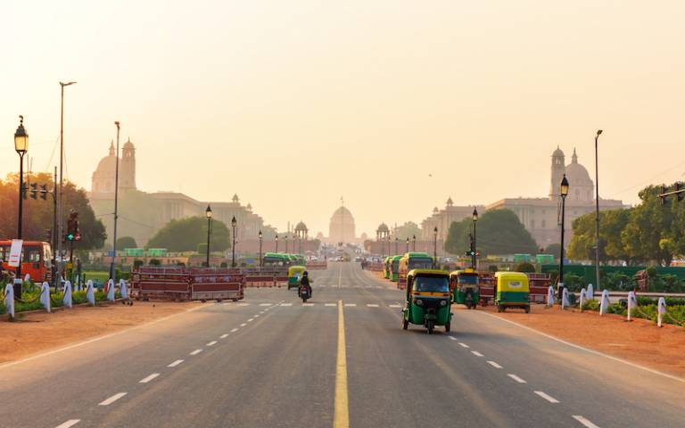 sunset traffic in New Delhi, tuc tuc cars on the road to the Presidential Residance.