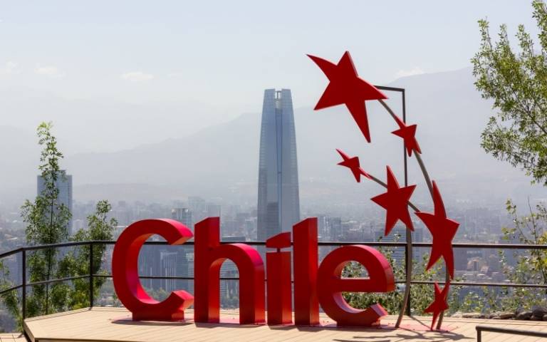 Chile red sign in San Cristobal mountain view point with Costanera Center building behind logo