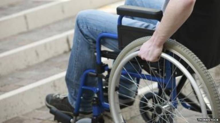 Image of wheelchair user at base of steps