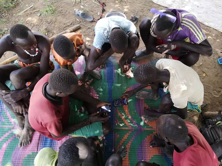 A group of Nyangatom agro-pastoralists mapping their land in a community gathering.