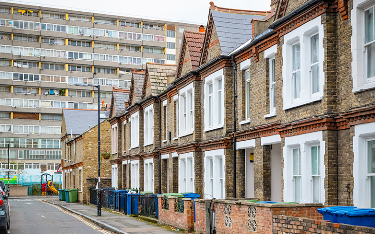 Traditional English terraced houses with huge council block in the background in south east London