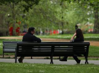 Image of people sitting on a bench in a park