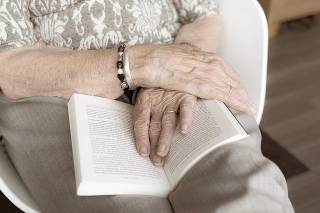 hands resting on open book