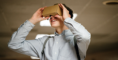 A young man tries on a cardboard VR headset