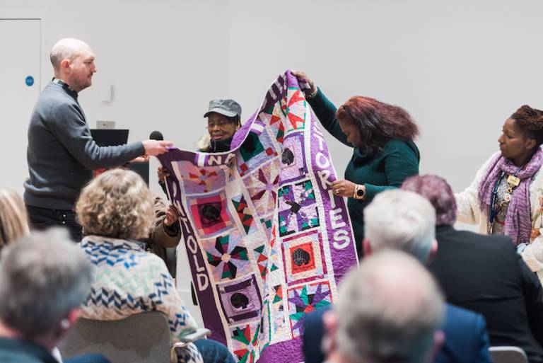 Care home residents show off a quilted blanket they made over lockdown