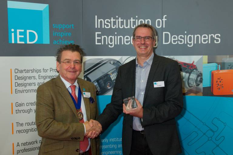 Prof Tim Baker shaking hands whilst winning award