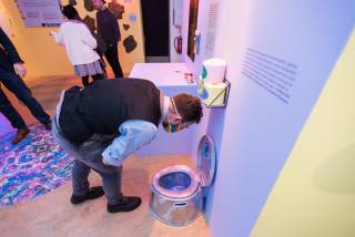 At exhibition man looking down toilet technology