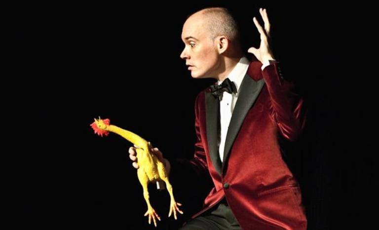 Shane Baker looking dramatic on stage with a rubber chicken