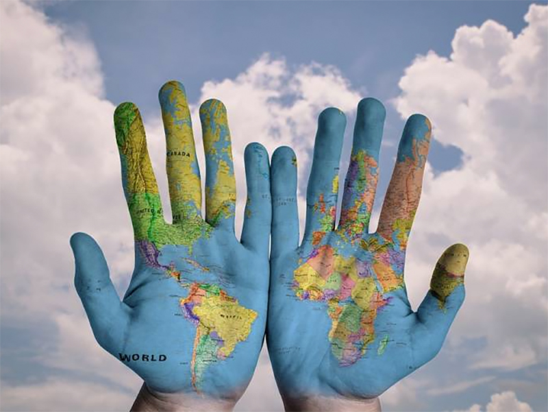 Hands showing a map of the world