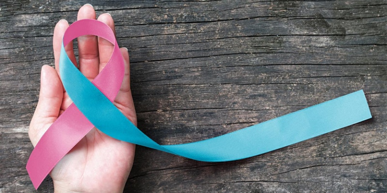 hand holding a pink and blue ribbon