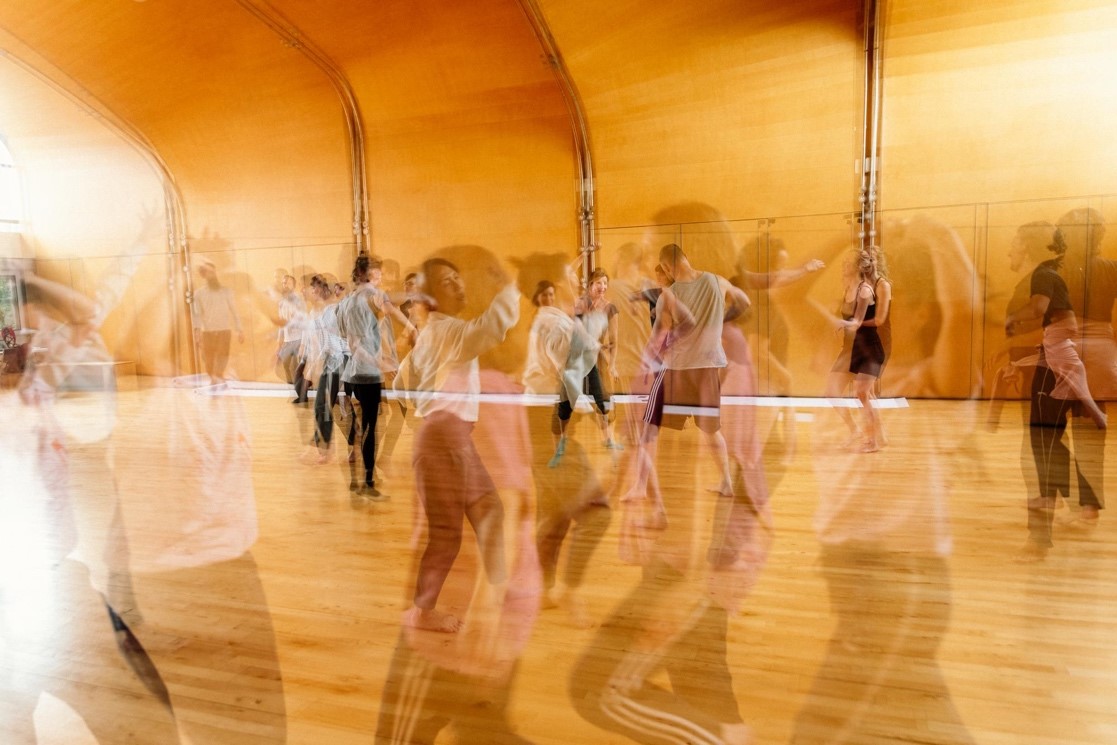 Performers in motion, with a blurred motion effect in a dance studio