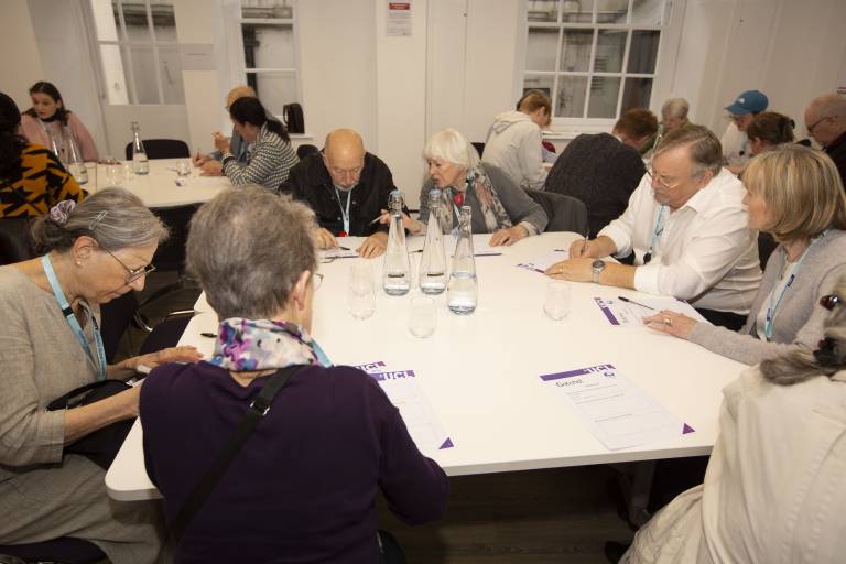 A group of people sitting around a table writing on worksheets