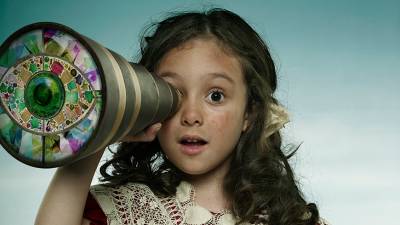 Girl looking through a telescope with a kaleidoscope pattern in the lense.