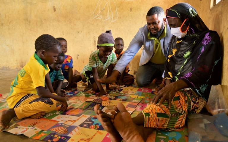 A family playing with children's cards in Ghana