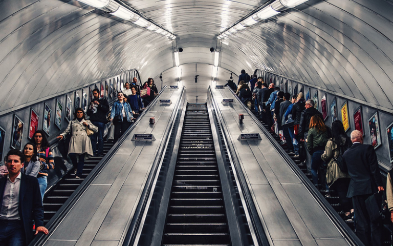 people riding an escalator on the tube