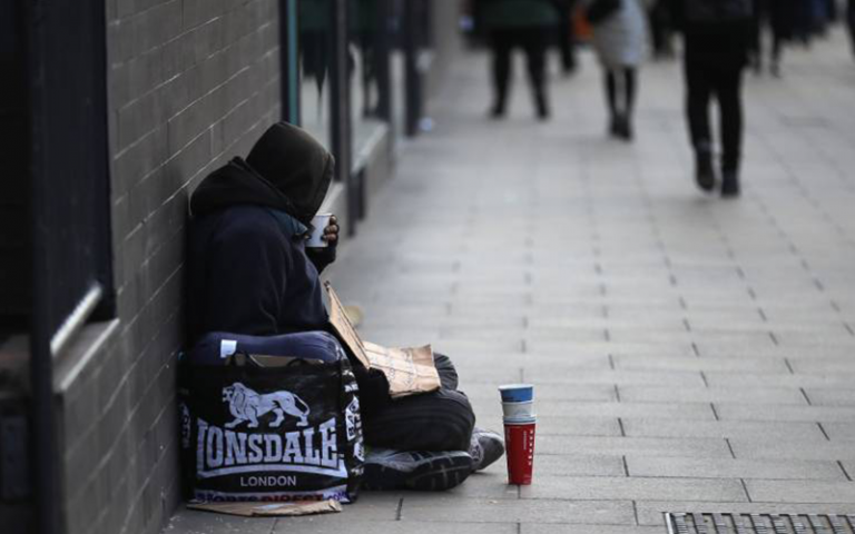 homeless man begs for small change on the streets of Manchester