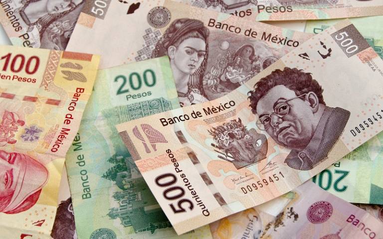 Mexican Pesos, bank notes, colorful background with diferent denominations including 500 pesos currency bills with Diego Rivera and Frida Kahlo faces.