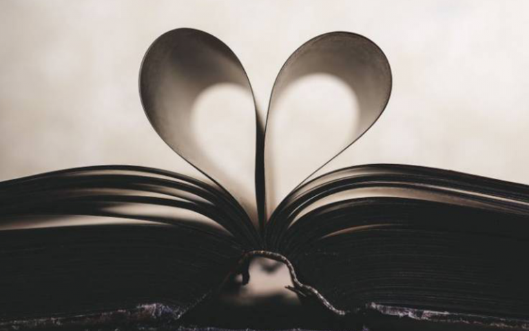 Open book with pages turned to create a heart shape.