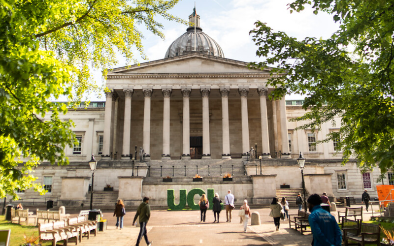 UCL quad in the spring with greenery around it, green UCL sign at the bottom of the steps