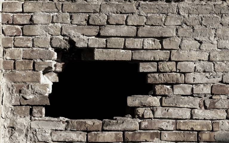 photo of a brick wall with a hole in