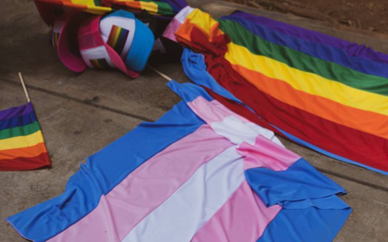 gay and trans flags bundled on the floor