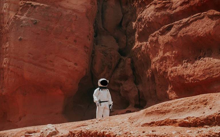 astronaut in mars type landscape, credit Nicolas Lobos on Unsplash