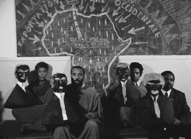 photo of black men sitting holding black puppets