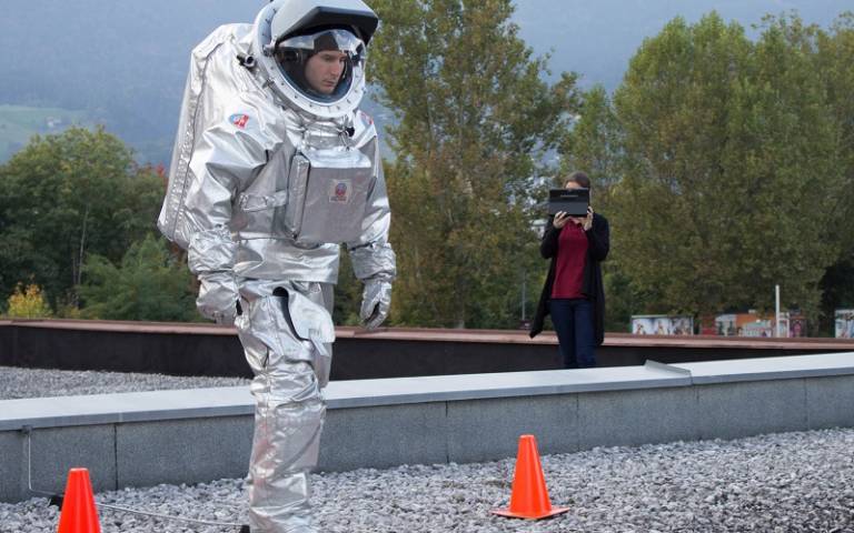 person in space suit practising movements on earth