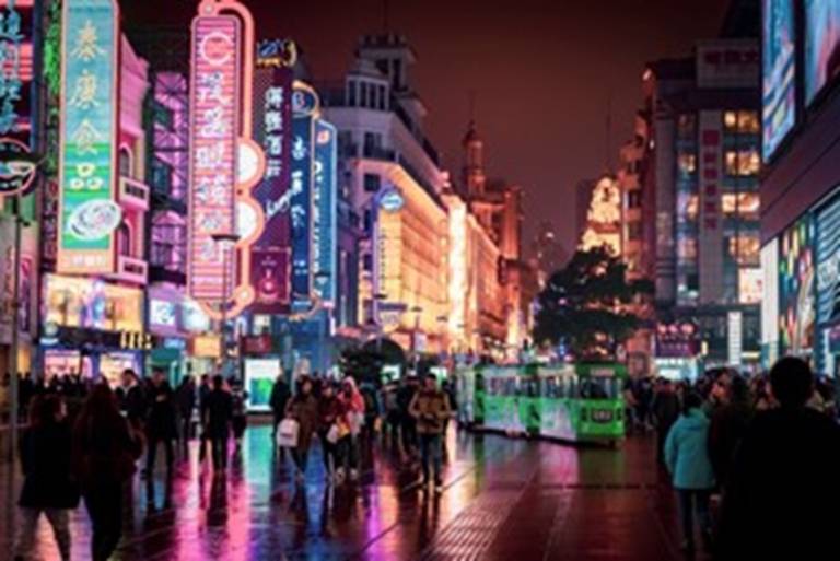 a street in China with neon signs and shops
