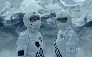 two people on a snowy mountain with spacesuits on