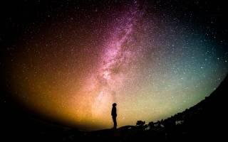Person looking at sky at night, credit Greg Rakozy via Unsplash