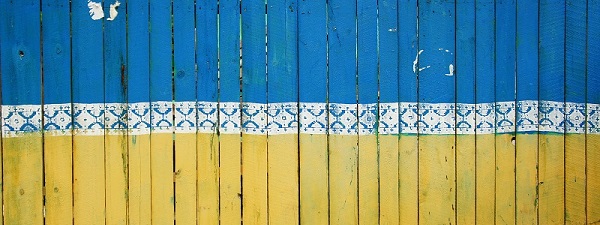 cropped image of fence painted with Ukraine flag, Tina Hartung on Unsplash