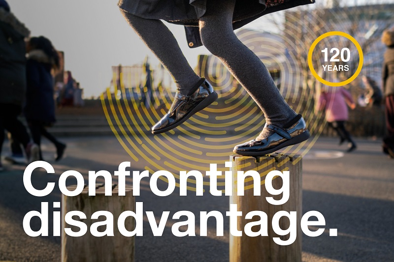 Child’s legs jumping on wooden blocks in a school playground with white text ‘Confronting disadvantage.’