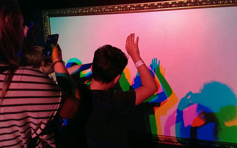 Children playing with projected colour silhouettes of themselves (Photo supplied by Youth Equity + STEM)