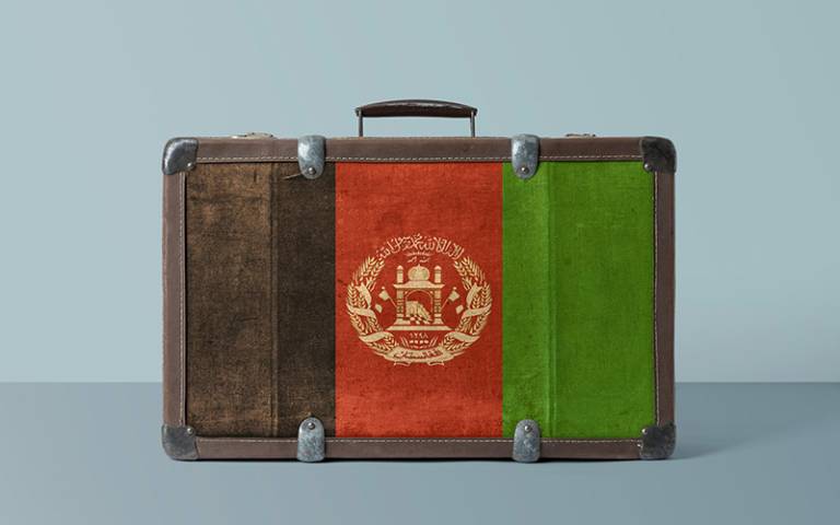 Flag of Afghanistan on an antique suitcase. Credit: Sezerozger / Adobe
