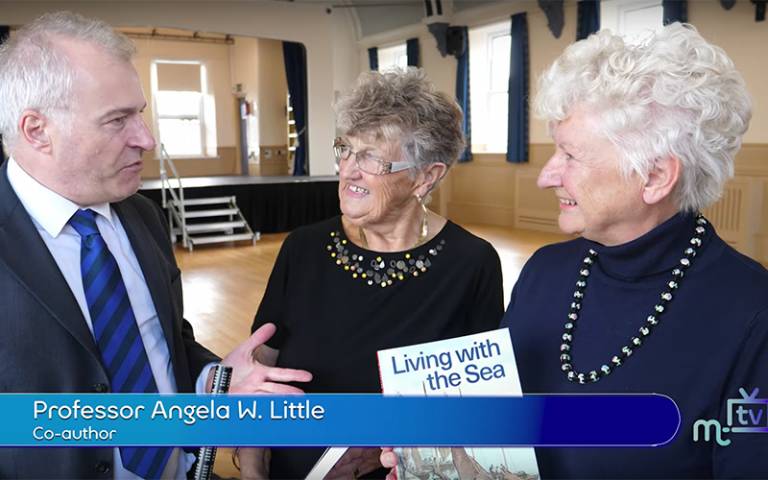 Professor Emerita Angela Little (far right; Screenshot from Isle of Man TV)