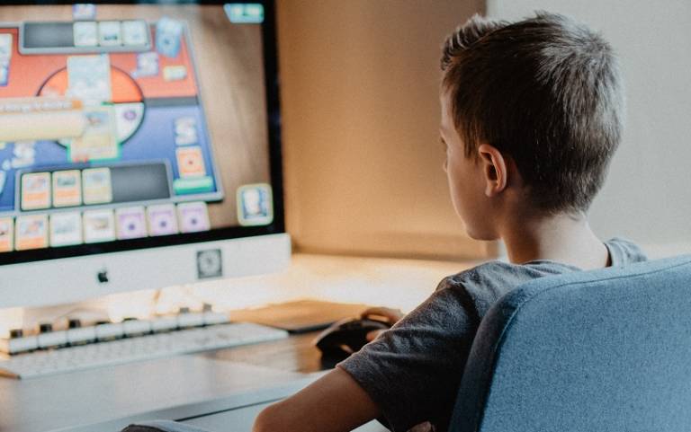 Boy sat at desk playing computer game