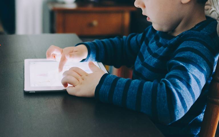 Boy using a tablet device at the table. Image: Kelly Sikkema