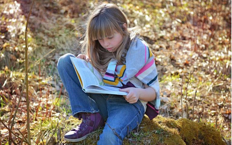 Child reading outdoors